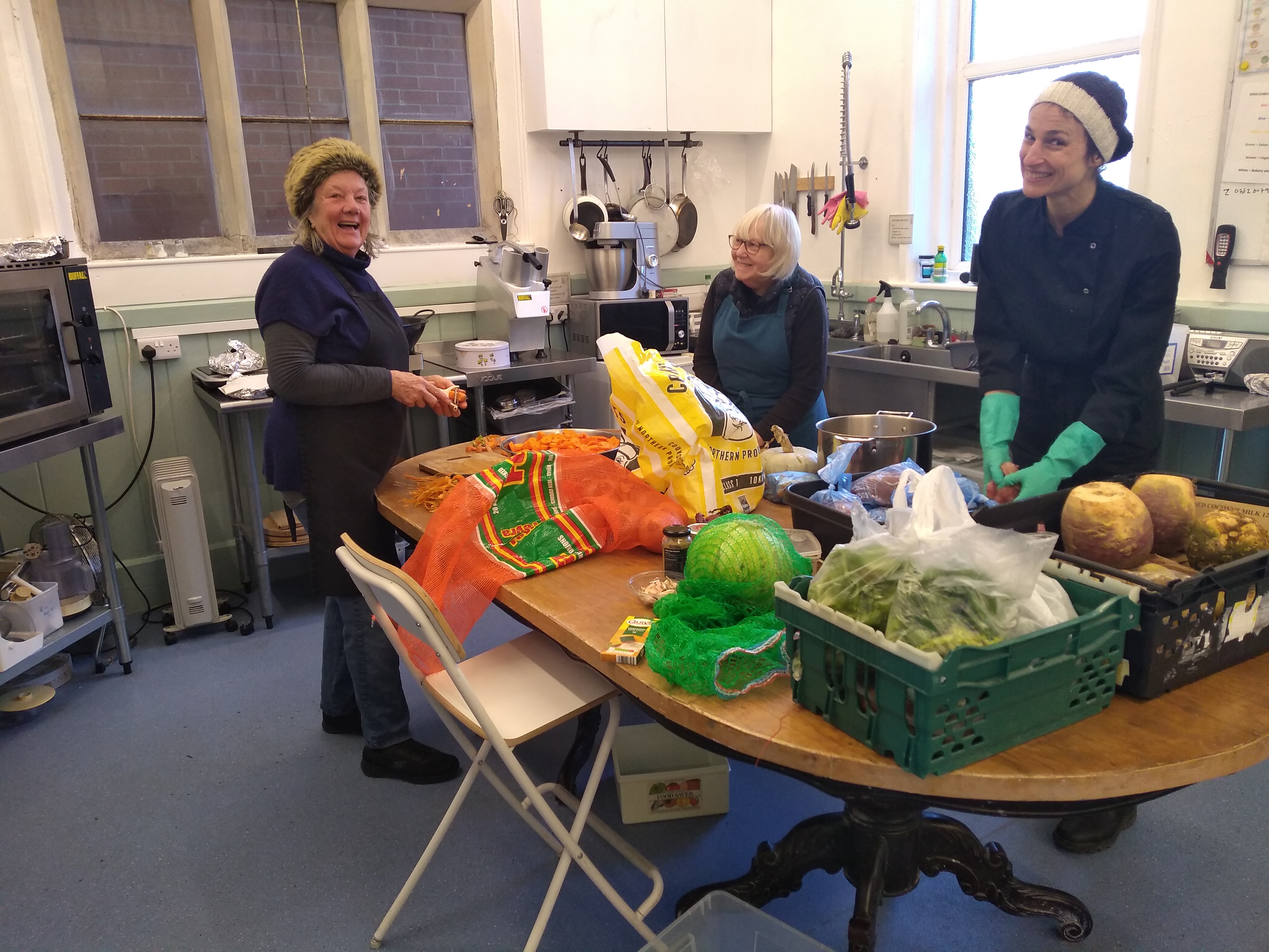L-R volunteers Carolyn St John, Catrin Unwin, and Chef Maria-Carin preparing food for the Friday Community Cafe where the Stroud Community Food Hub can feed up to 120 people on a pay as you can, if you can, basis.