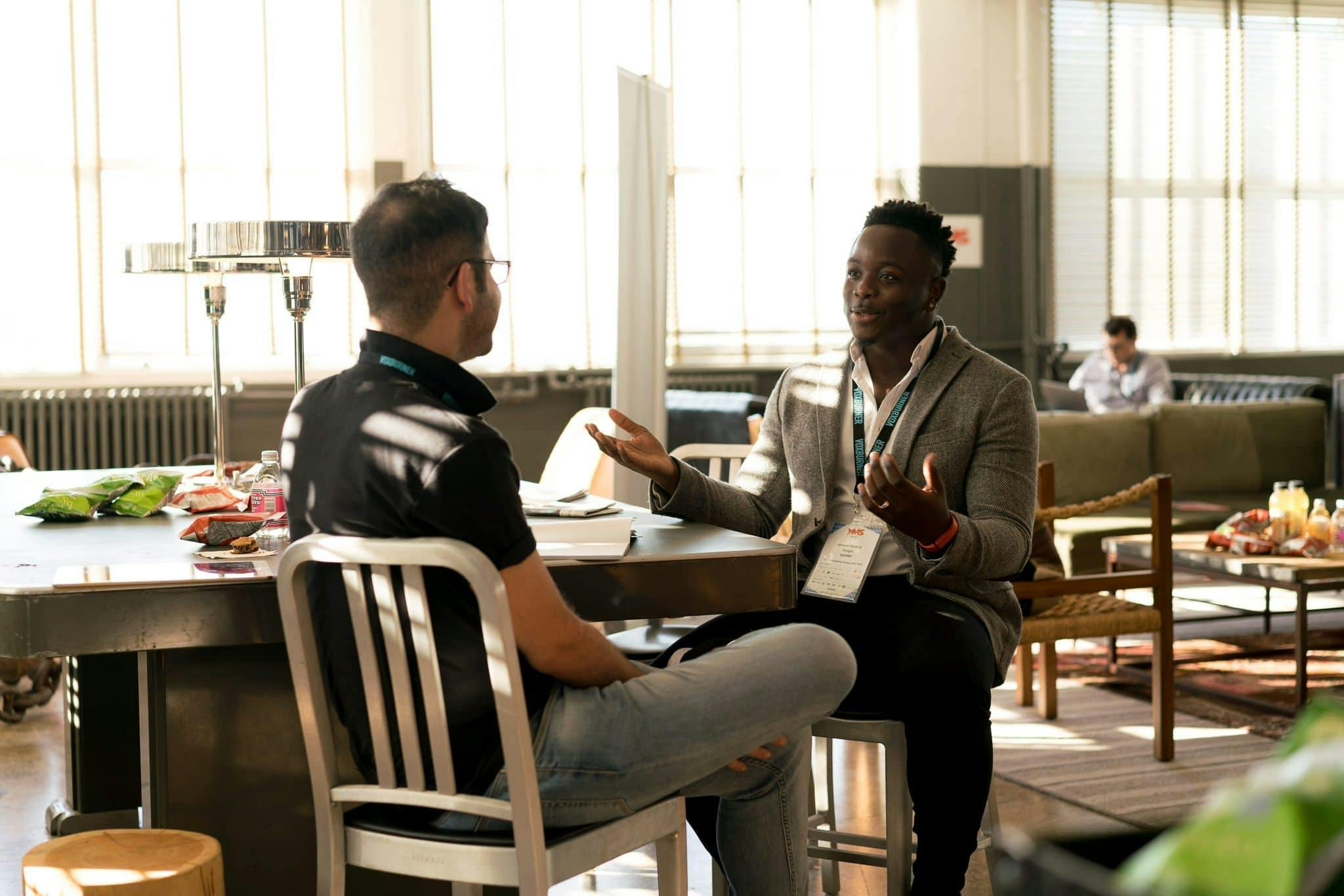 two people sitting facing each other talking